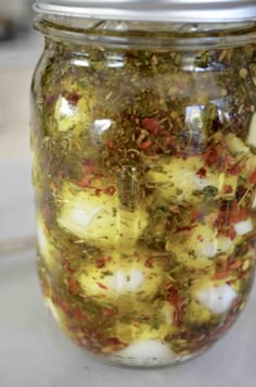 a jar filled with pickled vegetables sitting on top of a counter