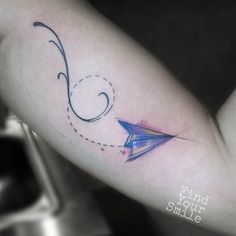 a woman's arm with an origami airplane tattoo on it