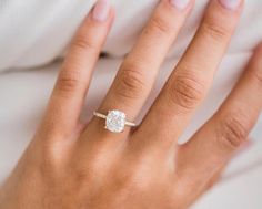 a woman's hand with a diamond ring on it