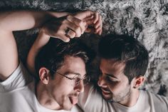 two men laying on the floor looking at something