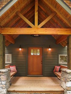 a wooden porch with two benches on the side and a door to another room behind it