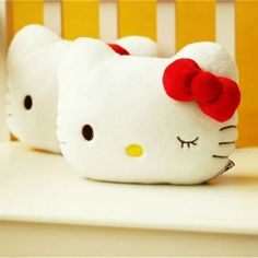 two hello kitty stuffed animals sitting on top of a white table next to each other