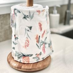 a roll of toilet paper sitting on top of a wooden stand