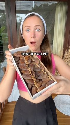 a woman holding up a box full of nuts with the caption that if you pit