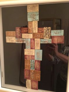 a cross made out of pieces of paper with words written on it and in the middle