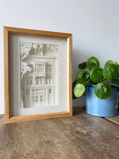 a wooden frame sitting on top of a table next to a potted plant