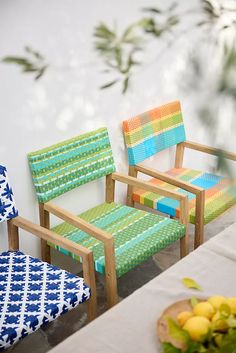 three chairs sitting next to each other near a table with fruit on top of it