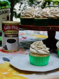 two cupcakes sitting on a plate next to a bottle of coffee