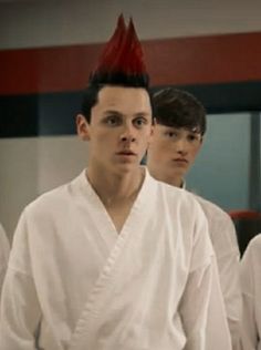 three young men in white uniforms standing next to each other with red mohawks on their heads