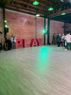 people are standing in the middle of a dance floor with letters spelling out play on it