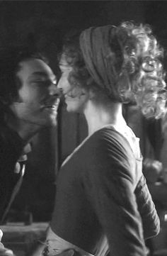 a man kissing a woman in front of a mirror