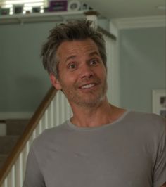 a man standing in front of a staircase with his eyes wide open and looking at the camera