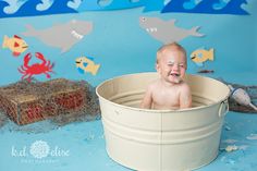 a baby is sitting in a bucket and smiling