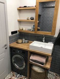 a washer and dryer in a bathroom with tile flooring on the walls