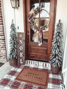 the front door is decorated for christmas with evergreens and pine cones on the mat