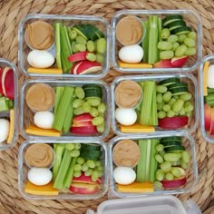 four plastic containers filled with food on top of a woven tablecloth covered flooring