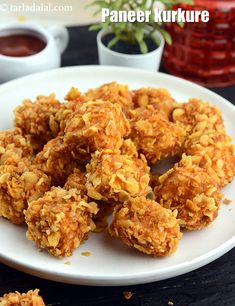 some fried food on a white plate with dipping sauce