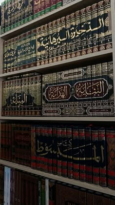 many books are lined up on shelves in a room with arabic writing and calligraphy