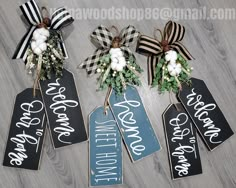 three black and white welcome home signs with burlocks on the front, one for each door hanger