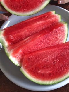 two slices of watermelon on a white plate