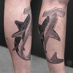 two shark tattoos on both legs, one with a hammer and the other with an anchor