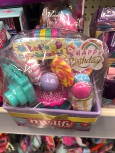 an assortment of birthday toys in a toy store display case with happy birthday greetings on it