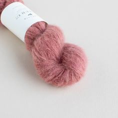 a skein of pink yarn sitting on top of a white surface