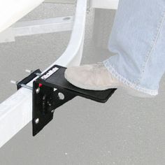 a pair of feet are standing on the edge of a boat's railing,