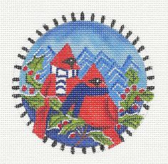 a cross stitch pattern with two red birds on the front and back of it, surrounded by holly branches