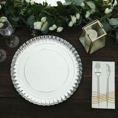 a table set with plates, silverware and flowers