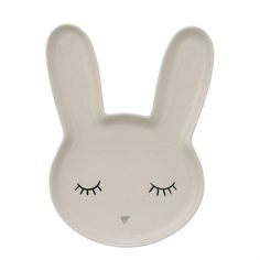 a white rabbit shaped plate with eyelashes on it