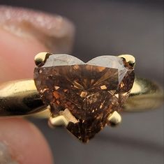 a heart shaped brown diamond being held in someone's hand