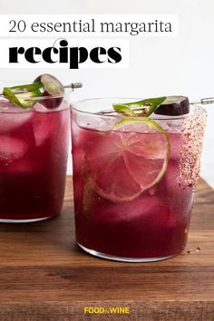 two glasses filled with liquid and garnish on top of a wooden cutting board