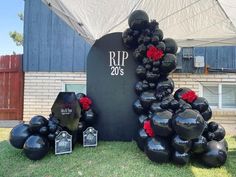 black and red balloons are arranged in front of a sign for rip 205's