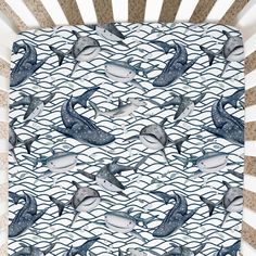 a baby crib with dolphins and waves on it