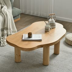 a wooden table sitting on top of a carpeted living room floor next to a couch