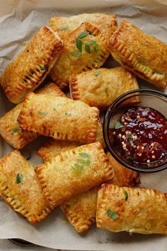 several pastries with dipping sauce on the side