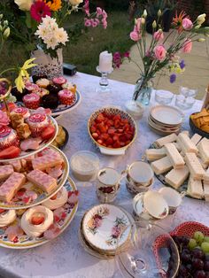 a table topped with lots of desserts and plates filled with cake on top of it