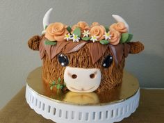 a cake with a cow's head and flowers on it