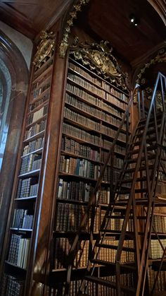 an old library filled with lots of books next to a tall wooden book case full of books