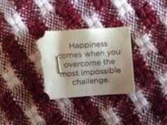 a piece of paper that says happiness comes when you overcome the most impossible challenge