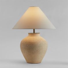 a table lamp with a white shade on it's base and a light bulb in the shape of a vase