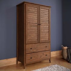 a wooden armoire sitting on top of a hard wood floor next to a rug