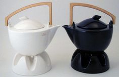 two ceramic teapots sitting next to each other on top of a white table