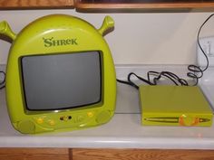 there is a small yellow computer on top of the counter next to it's charger