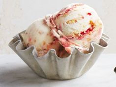 two scoops of ice cream sitting on top of a table next to an apple