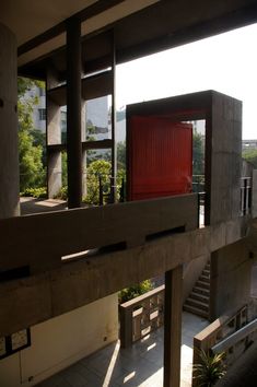 an open red door on the side of a building with stairs leading up to it