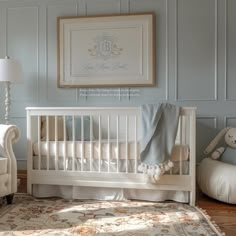 a baby's room with a white crib, chair and rug on the floor