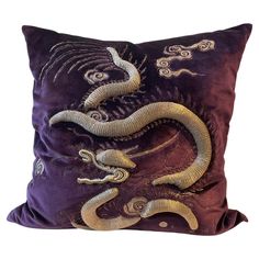 a decorative pillow with two snakes on the front and one snake on the back, in purple velvet