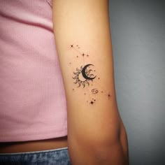 a woman's arm with a small sun and moon tattoo on the left inner arm